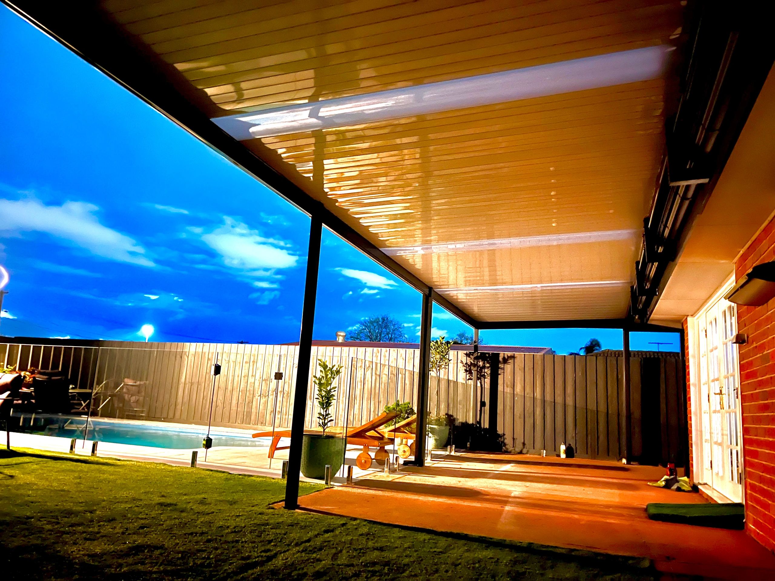 Backyard patio with pool at dusk